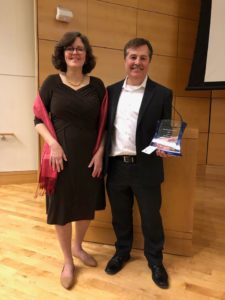 Eric Blom stands next to his wife Lynn holding the 2019 Edward L. Bernays Achievement Award.