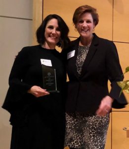 Marnie Grumbach, holding the 2019 President’s Award, stands next to MPRC President Linda Varrell